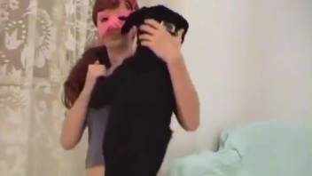 Veiled beauty prepares to fellate a canine's penis
